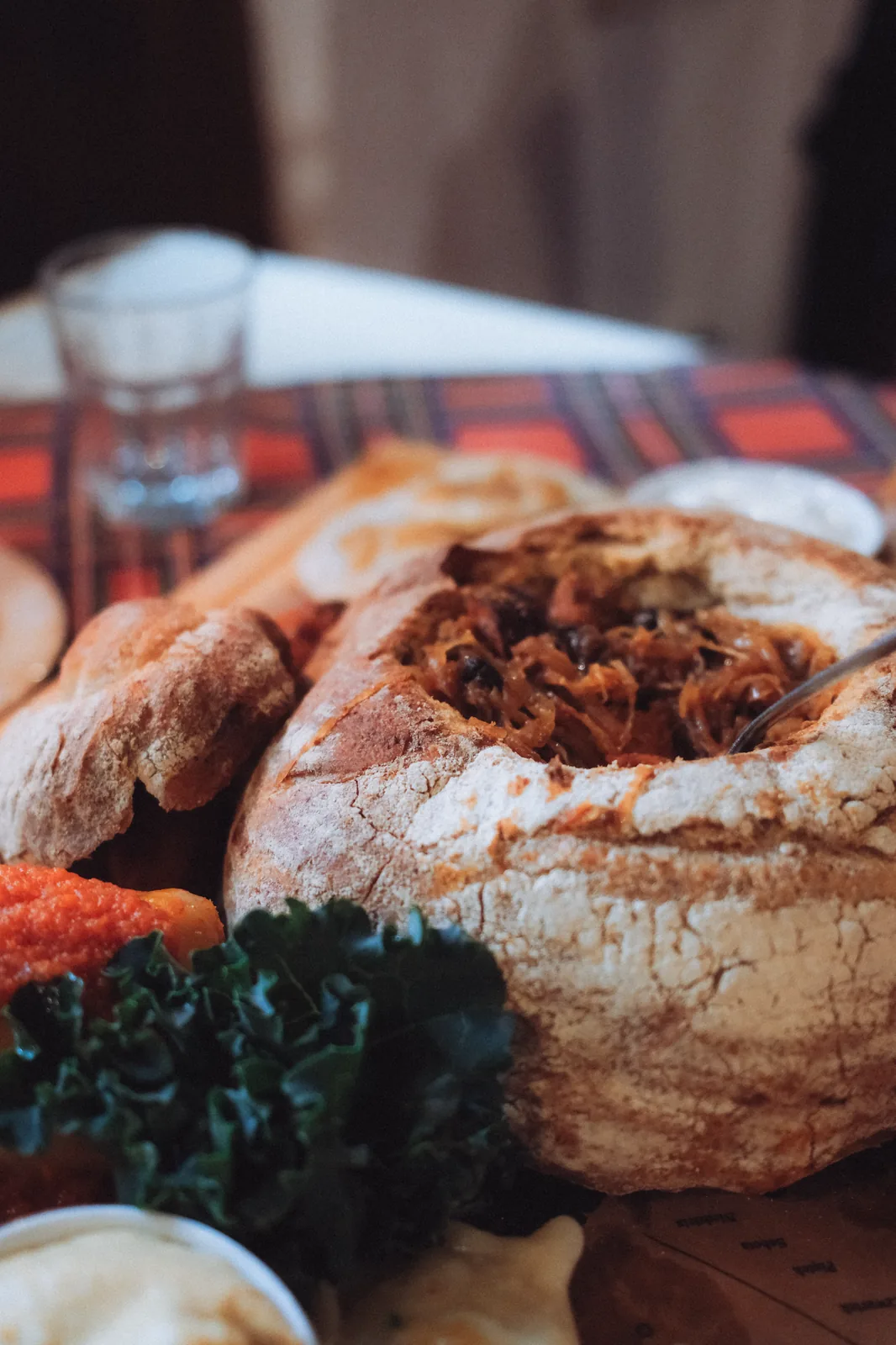 Bigos, Polish hunter's stew, served in a hollowed bread bowl alongside dumplings